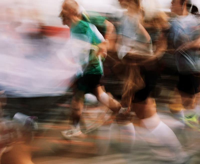 A pack of runners in motion at the start of a race