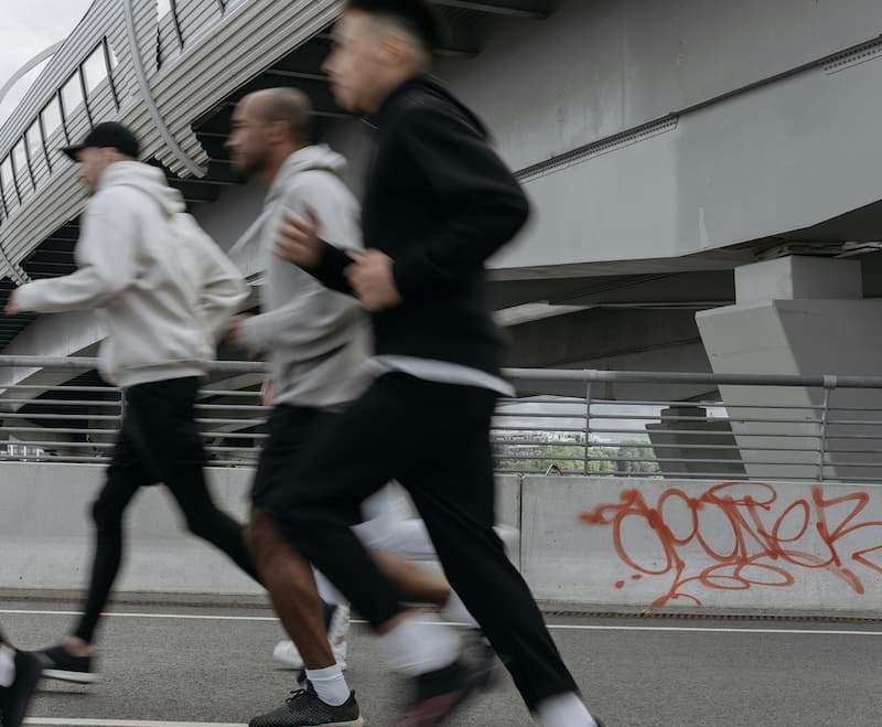 Group of runners passing under a city overpass